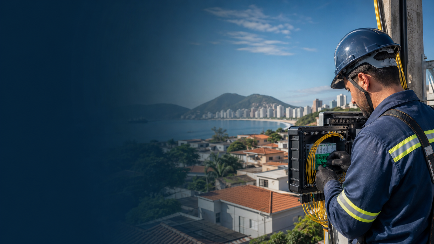 Técnico de telecomunicações trabalhando em caixa de fibra óptica com cidade litorânea ao fundo